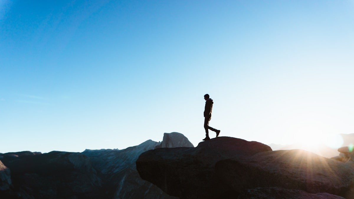 silhouette of man on peak